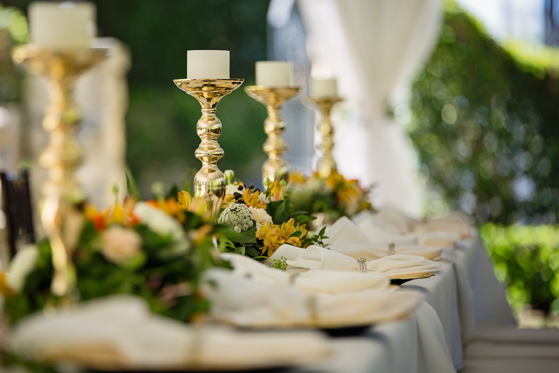 Elegant table setting with gold candle holders and floral arrangements